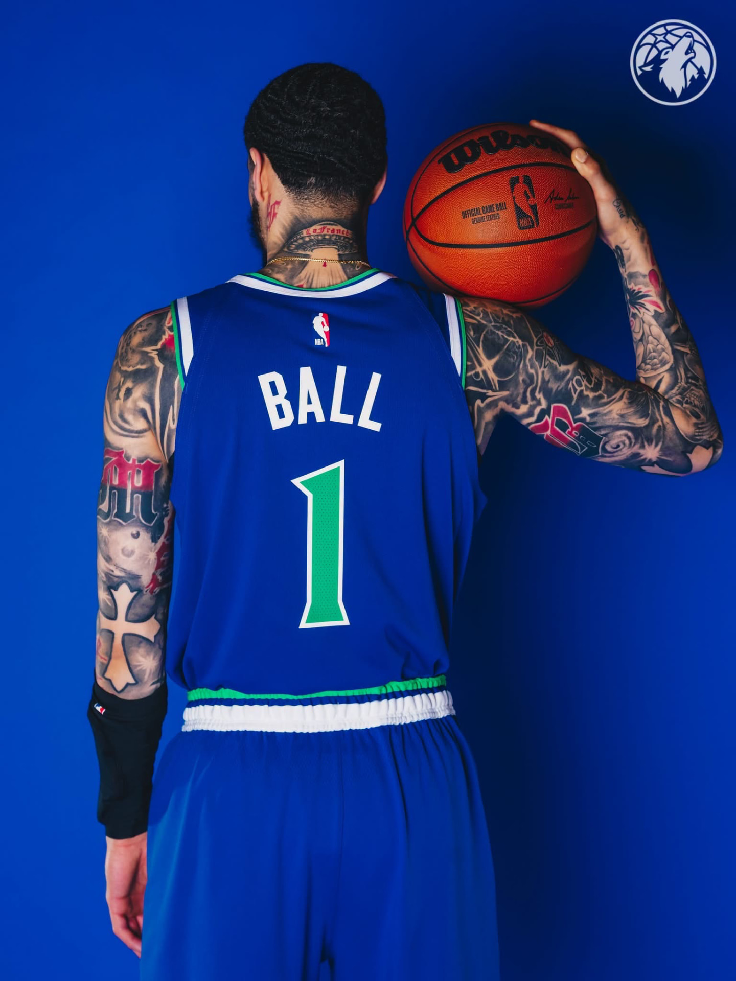 LaMelo Ball from behind in a blue Wolves #1 jersey, ball on his shoulder